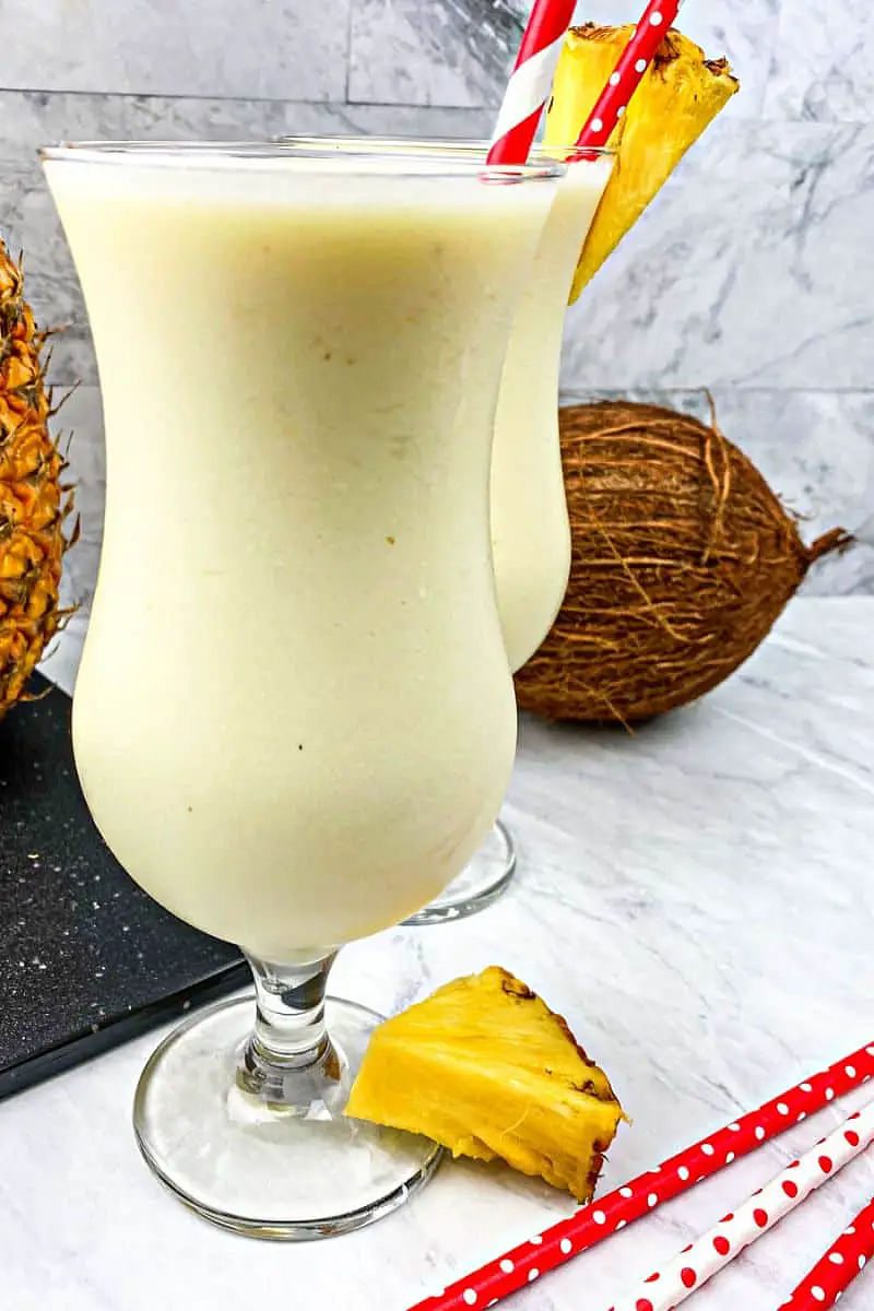 blended pina colada mocktail in a glass with pineapple garnish